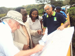 The two Ministers (in the middle) study a plan alongside the project engineers. (Photo S. Rwembeho.)