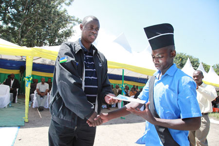 James Kabarebe the minister of defense presents an award to Abdulilah Nkundimana the best student in Commercial farming