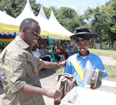 Prime Minister Bernard Makuza awards Gahenda Mpuhwe as the best student in Beekeeping during the graduation ceremony
