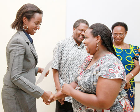 The head of Tourism and Conservation Rica Rwigamba (Left) awards a certificate to Jacqueline Duniah, an expert in tourism development (Photo T.Kisambira).