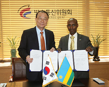 Choi See Joong, the Chairman of KCC-South Korea with  Minister in charge of ICT Ignace Gatare after signing an agreement for cooperation early last week. (Courtesy photo).