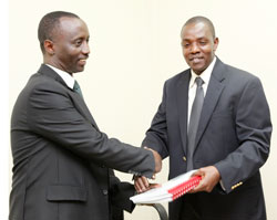 The new National Agriculture and Export board boss Alex Kanyankole (L) receives documents from the former director of RHODA Dr. Ndambe Nzaramba (Photo; T. Kisambira)