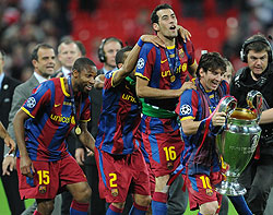 Lionel Messi (R) and teammates celebrate with the trophy at the end of the UEFA Champions League final. (Net photo)