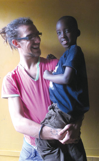 Brad Synder carries Akaliza at the Gisimba orphanage, months later after the heart surgery. (Photo by D. Umutesi)