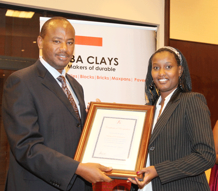Minister Nsengiyumva presents a certificate to Lillian Mupende, Kigali City's Director of Urban Planning, in recorgnition of the support in organising the symposium (Photo T.Kisambira)