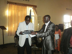 Nyamasheke Mayor, Jean Baptiste Habyarimana, hands over a laptop to Bushenge Sector Executive Secretary (Courtesy photo)