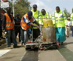  A traffic police officer joins workers to paint zebra-crossing signs at the launch of the Road Safety Week (Photo B Asiimwe)