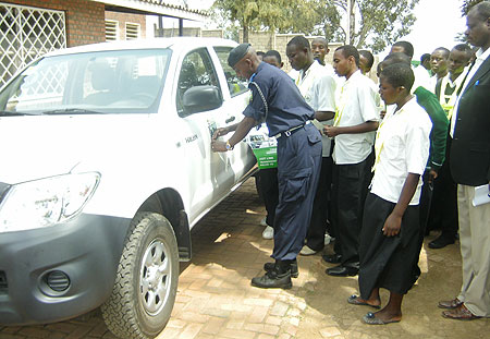 The Karongi District Police Commander demonstrates to the students how to place the stickers during the Road Safety Week (photo S Nkurunziza