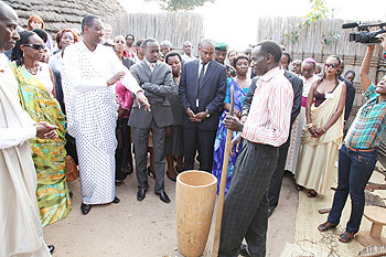A drum maker illustrating to government officials the stages of making a drum.