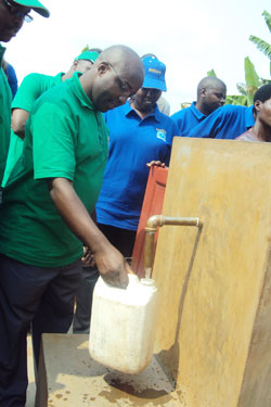 Alexis Nzahabwanimana fetches water during the inauguration ceremony (Photo: Bucyensenge)