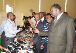 Minister of trade and Industry, Francois Kanimba, (R) and RBS Director Genera,l Mark Cyubahiro Bagabe  admiring Rwandan made shoes at the crafts expo. (Photo J Mbanda)