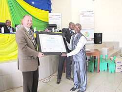  William Sparks (R) gives a certificate of merit to a farmer (Photo by S. Rwembeho)