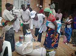 Returnees from Uganda receive food items at a transit camp  before heading to their respective homes. More have returned from DRC (File photo)