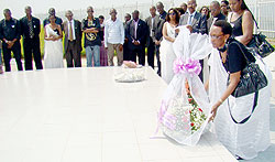 Marie Immaculee Ingabire lays a wreath at the mass grave. (Photo. G. Mugoya)
