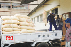 Workers at Kabuye sugar loading a truck with sacks of sugar.  (Photo / J.Mbanda)