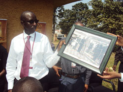 Museums boss Umulisa receives a photo of King Rudahigwa inaugurating the Bralirwa plan tin 1959 (Photo JP Bucyensenge)