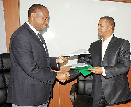 The Minister of Infrastructure, Albert Nsengiyumva, (L) hands over to new WDA Director General, Jerome Gasana, yesterday. (J Mbanda)