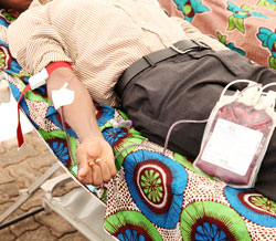 An employee of Rwanda Revenue donates blood as part of the events to mark the 10th Taxpayers Day,  (T.Kisambira)