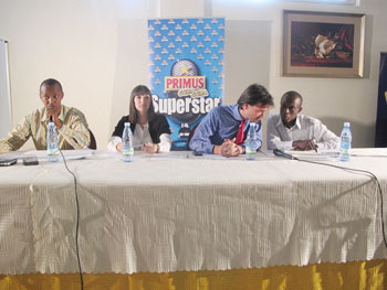 (R-L) An official from Bralirwa chats with Alexander Koch, Bralirwau2019s Commercial Director during a press conference at Top Tower Hotel. Looking on (from left) is Joseph Mushyoma, the CEO of East African Promoters (Photo / Linda)