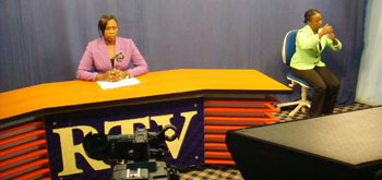A Rwanda National Television news anchor (L) with someone speaking to those with hearing disability (Courtesy photo)