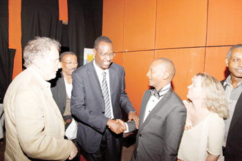 The Minister of Sports, Youth and Culture Protais Mitali (C) congratulates Eric Kabera, founder of the Rwanda Cinema Center. Hollywood guests look on.