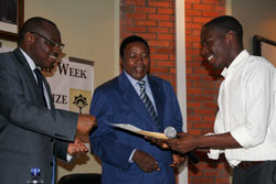  BNR GovernorGatete (Right) hands the African Innovative Prize to the winner Patrice Habinshuti, as KIST Vice Rector Prof John Mshana looks on. The New Times /Emma Munyaneza.