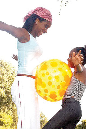 Mother and daughter holding beach ball without hands. Net photo