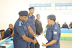 Police Chief, Emmanuel Gasana hands over a certificate to one of the trainees as the head of CID, Christophe Bizimungu looks on NewTimes/Courtesy.
