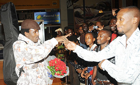 Alpha Rwirangira greets fans at Kigali International airport yesterday. The New Times John Mbanda)