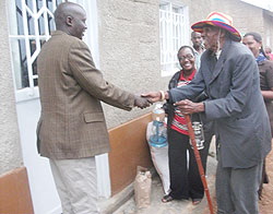 The Mayor of Kicukiro, Jules Ndamage,, hands over a house to 91 year old Athanase Kamomodo. The New Times /Grace Mugoya.