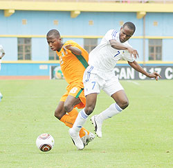 Charles Tibingana (R) fights for the ball with an Ivory Coast player during the 2011 Africa Junior Championship. The New Times/File Photo