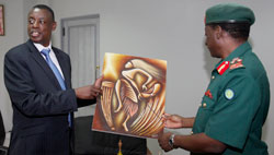  Gen Davis Mwamunyange, (R) admires a piece of art presented to him by Defence minister James Kabarebe .The New Times/T.Kisambira