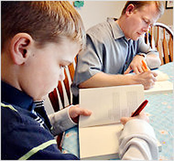Colton Burpo and his father Todd Burpo sign copies of u201cHeaven Is for Realu201d in their Imperial, Neb., home.