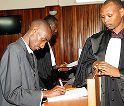 Ousted Member of Parliament Alexandre Damas Ashinzwuwera (L) signs the court's verdict as  Registrar Germain Rusingiza looks on. The New Times /Timothy Kisambira