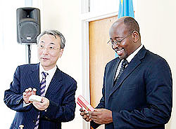 Local Gov't Minister, James Musoni,(R) admires a gift from Kim Won Jin, from the Korean Ministry of Public Administration and Security yesterday. The New Times/ Timothy Kisambira