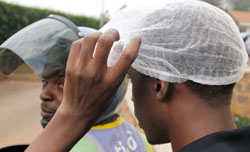 A Taxi-moto passenger tries on the smart cover head. The NewTimes /Timothy Kisambira