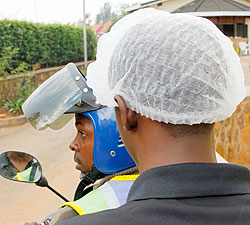  Controversy is brewing over who should meet the cost of the smart cover headgear offered to passengers using taxi-motos. The New Times/ File photo