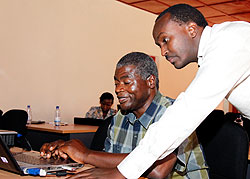 Dr Claude Rutanga , in charge of TB Infection Control Unit chats with Dr Amos Kutwa a consultant from KNCU East African Region yesterday.  The New Times Timothy Kisambira