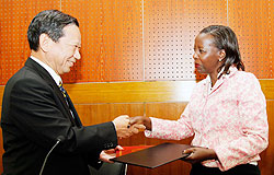 The Japanese Ambassador to Rwanda Kunio Hatanaka (L), exchanges documents with Foreign Affairs Minister Louise Mushikiwabo after signing a grant yesterday.The New Times /Timothy Kisambira.