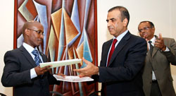  ICT Minister, Ignace Gatare, (L) exchanges documents with Sunil Bharti Mittal, chairman and director of Bharti Artel. The New Times /Timothy Kisambira