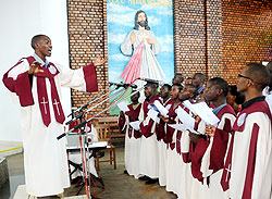 The choirmaster leads members and other worshippers to sing at Remera-based Regina Pacis during a memorial service of the US 9-11 victims yesterday.  The New Times/ John Mbanda