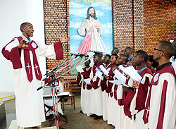 The choirmaster leads members and other worshippers to sing at Remera-based Regina Pacis during a memorial service of the US 9-11 victims yesterday.  The New Times/ John Mbanda