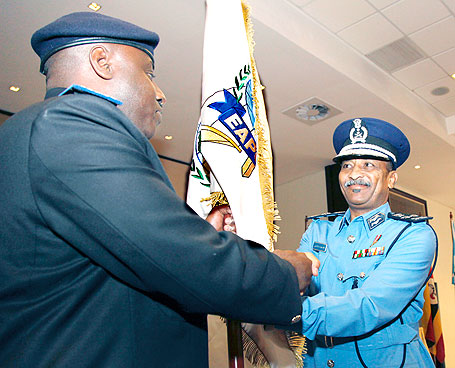 Sudanu2019s Gen. Hashim Osman Ali Hussein handing over EAPCCO's flag to his successor, IGP Emmanuel Gasana. The New Times/ Timothy Kisambira