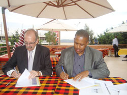 WDA's Jerome Gasana and SHair Academy's Nigel McCarthy sign the agreement to institute a hair dressing academy in Rwanda. The New Times /courtesy.