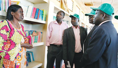 Irene Munimpundu (L), a librarian at Lycee de Kigali shows around some of the schoolu2019s Old Boys including Christopher Bazivamo (R) and Augustine Mutijima(2R), both members of the newly formed alumni committee, yesterday. The New Times/Timothy Kisambira.