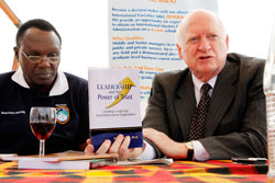 Dr Mike Armour, (R) displays one of his books on Leadership. Looking on is Professor Musa Nyakora Rector of Mount Kenya University- Rwanda. The New Times /Timothy Kisambira