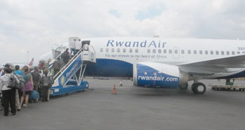 Passengers embark on a Rwandair plane at the Kigali Airport. The national carrier has upped its services. The New Times /File.