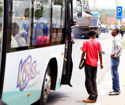 Commuters at a Kigali bus stop. Commuters have raised concerns  insufficient bus stops on some routes which compel them to walk long distances. New Times /Timothy Kisambira
