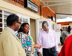 Mayor Solange Mukasonga, (C) talks to Francois Nsengiyumva(L) of Atraco and  Charles Ngarambe (R) the Chairman of the Transportersu2019 association on her arrival at the new offices of OMEGA Express one of the upcountry bus operators. The New Times/Timothy Ki