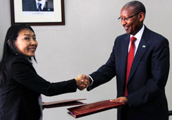 The Minister of Finance, John Rwangombwa, (R) exchanging documents with the vice president of IFAD, Yukiko Omura. The New Times /Timothy Kisambira